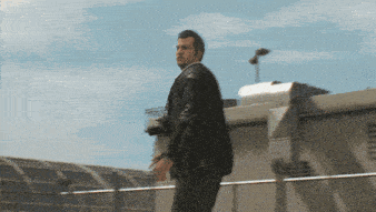 a man in a black leather jacket is standing on a rooftop holding a camera