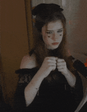 a woman with hearts on her face is looking at something