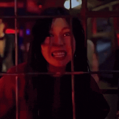 a woman behind bars with her mouth open and a man behind her