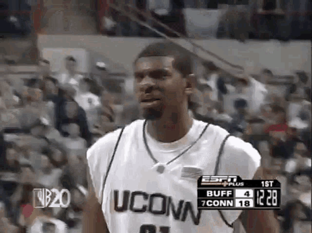 a man wearing a uconn jersey is standing in front of a crowd