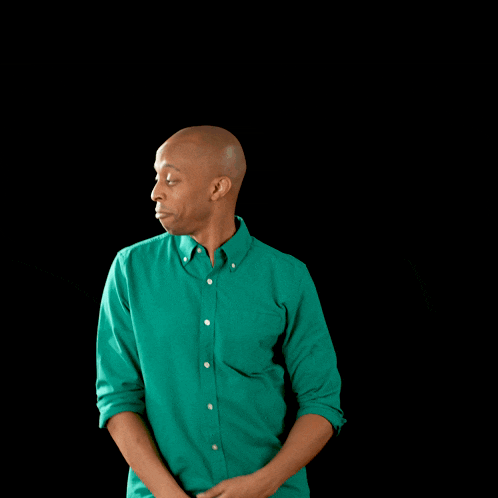 a man in a green shirt is standing with his hands on his hips