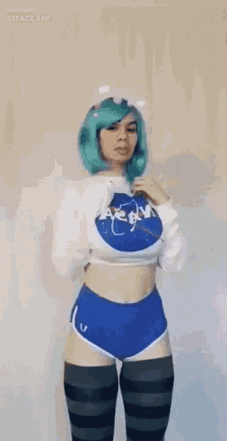 a woman with green hair is wearing a nasa shirt and shorts and knee high socks .