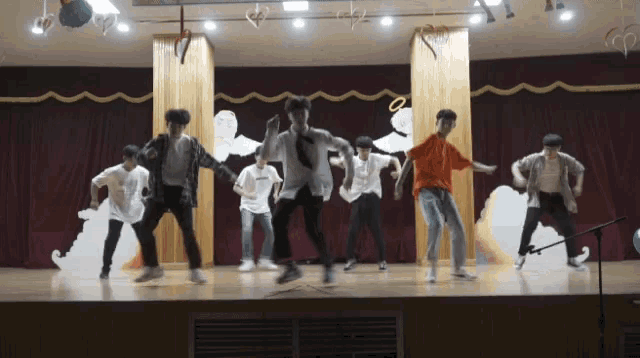 a group of young men are dancing on stage