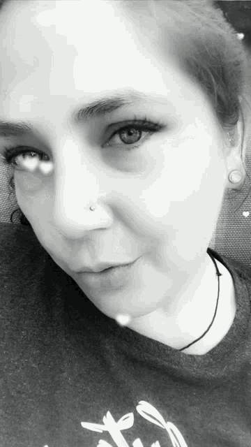 a close up of a woman 's face with a nose ring on it