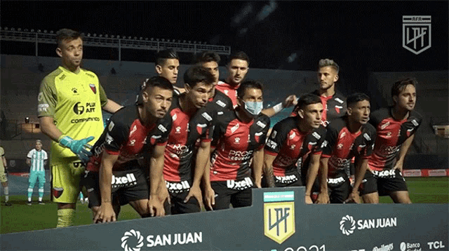 a group of soccer players pose for a photo in front of a banner that says san juan