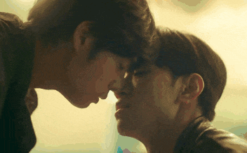 two men kissing each other on the forehead in a blurry photo