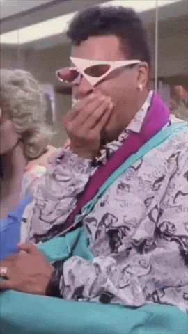 a man wearing sunglasses is covering his mouth