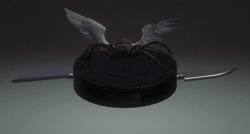 a statue of a spider with white wings on a black object