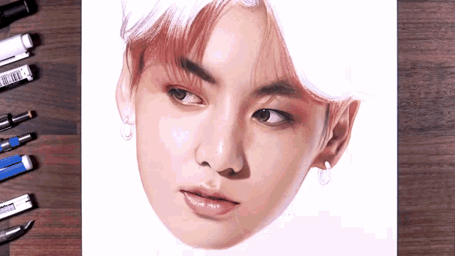 a drawing of a young man 's face is being completed