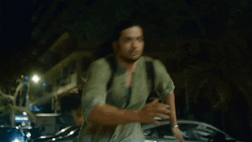 a man with long hair is walking down the street with a backpack .
