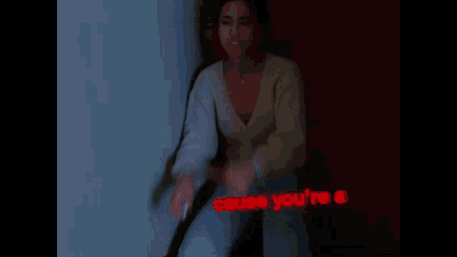 a woman in a white sweater is standing in a dark room with the word beach above her