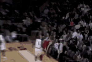 a blurry picture of a basketball game with a player wearing a white jersey with the number 9 on it