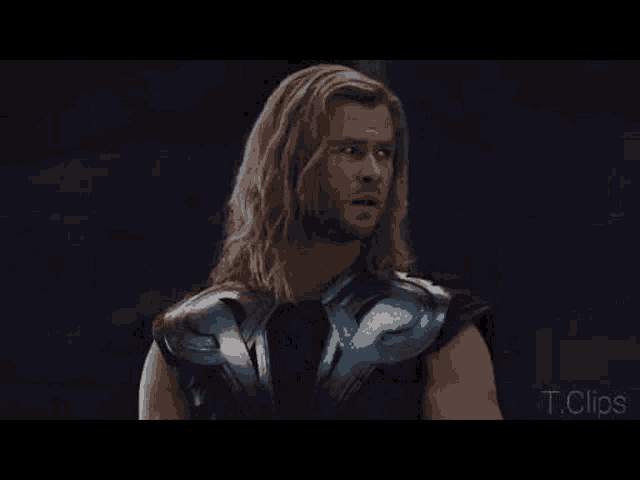 a man with long hair and a beard is standing in front of a dark background and says `` no entiendo '' .