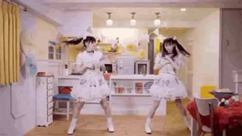 two girls are dancing together in a living room .