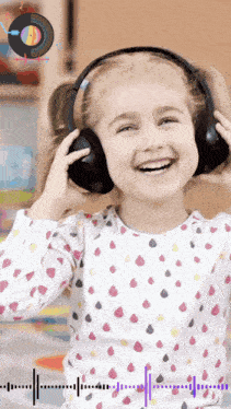 a little girl wearing headphones and smiling with a record in the background