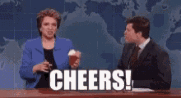a man and a woman are sitting at a table with the words `` cheers ! '' written on the screen .
