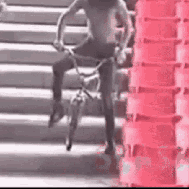 a shirtless man is riding a bike down a set of stairs