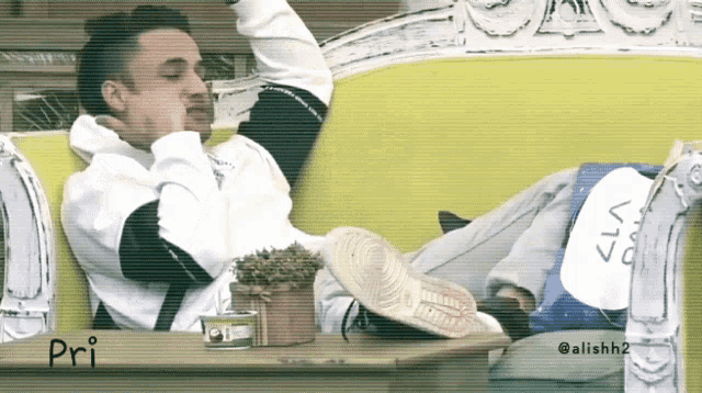 a man laying on a couch with pri written on the table