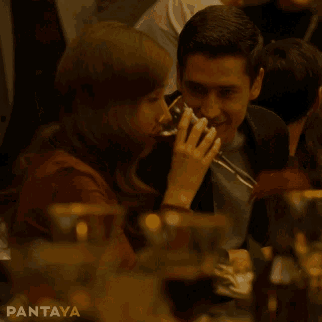 a man and a woman are sitting at a table with pantaya written on the bottom right