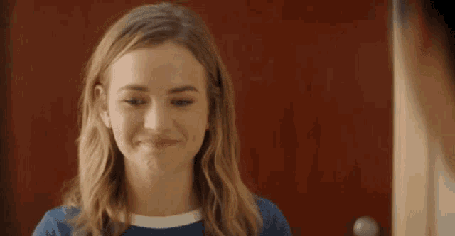 a woman with blonde hair is smiling and looking at the camera .