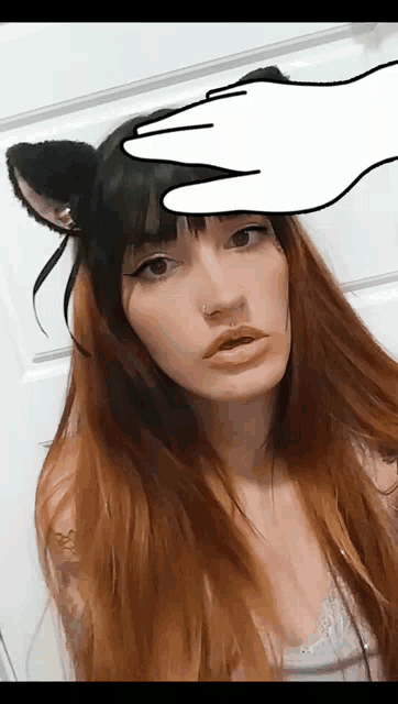 a woman wearing cat ears has a hand drawn on her head