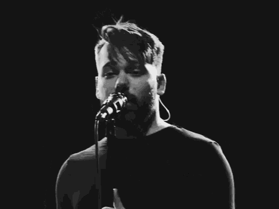 a man singing into a microphone with the words " what are all these words " above him
