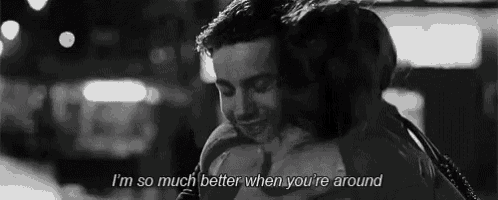 a man is hugging a woman in a black and white photo with a quote on it .