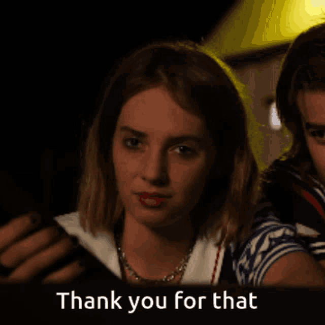 a woman says thank you for that in front of a dark background
