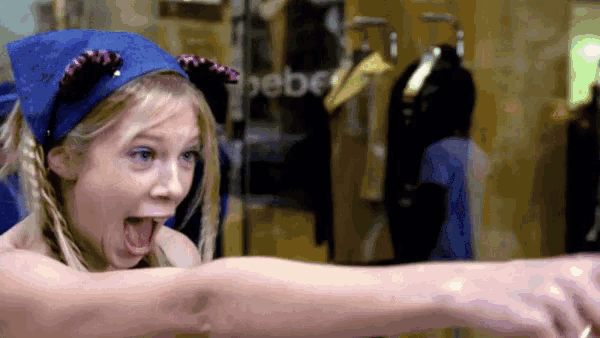 a girl wearing a blue headband with cat ears is pointing