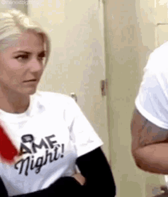 a woman wearing a t-shirt that says `` game night '' is talking to a man .
