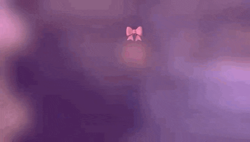 a man wearing a pink bow tie is standing in front of a wooden fence .