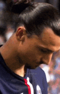 a close up of a man 's face with a bun