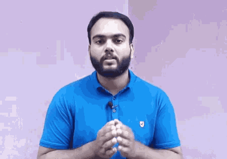 a man with a beard is wearing a blue polo shirt