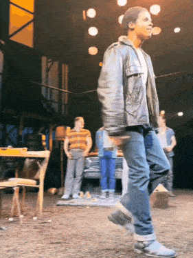 a man in a leather jacket stands on a stage