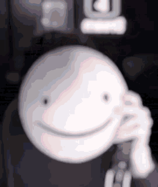 a close up of a smiley face with a remote control in front of it .