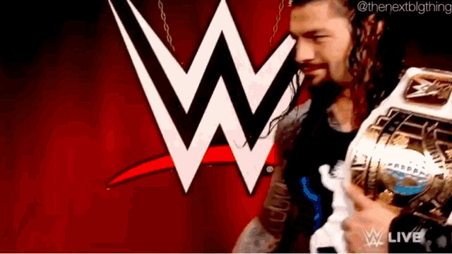 a man holding a wrestling trophy in front of a wwe logo