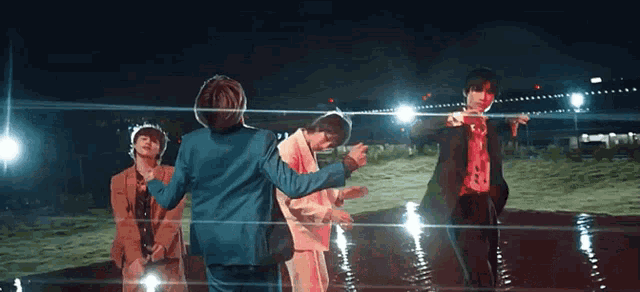 a group of people are dancing in a field at night .