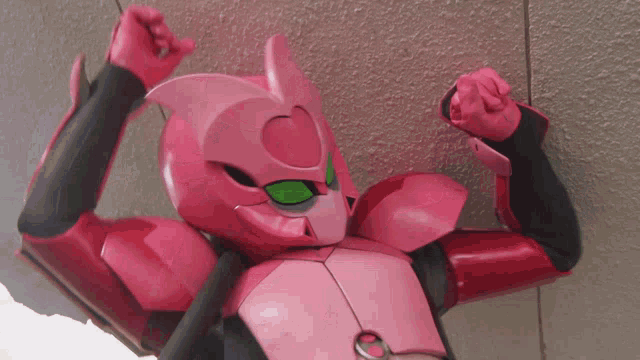 a pink robot is flexing his muscles in front of a wall