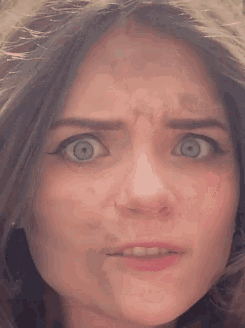 a close up of a woman 's face with a surprised expression