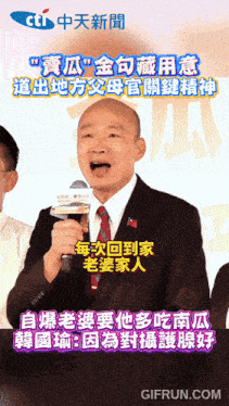 a man in a suit and tie is speaking into a microphone with chinese writing on the bottom