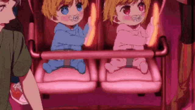 two babies are sitting on a roller coaster with a person standing behind them .