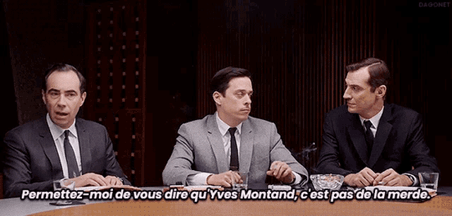 three men in suits and ties are sitting around a table with the caption " permettez-moi de vous dire qu yves montand "