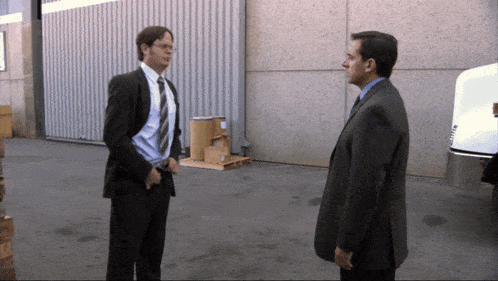a man in a suit and tie is talking to another man