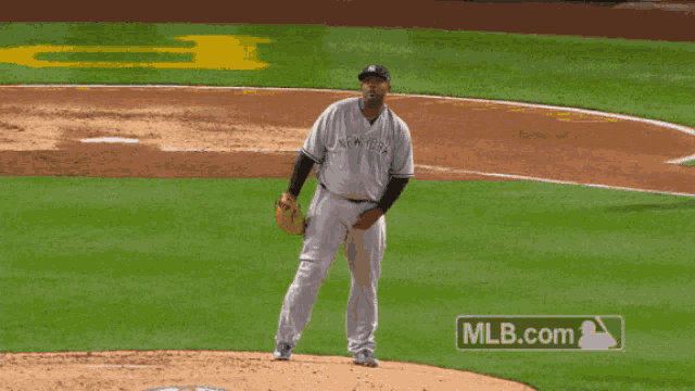 a man in a new york yankees jersey throws a ball