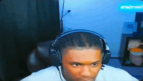 a man wearing headphones is sitting in a chair in front of a television .