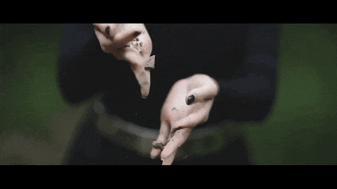 a close up of a woman 's hands holding rocks and dirt .
