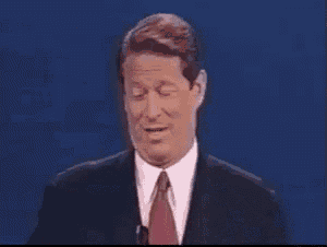 a man in a suit and tie is giving a speech on a stage .