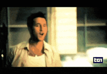 a man in a white shirt is standing in front of a window with the letters cgi on the bottom