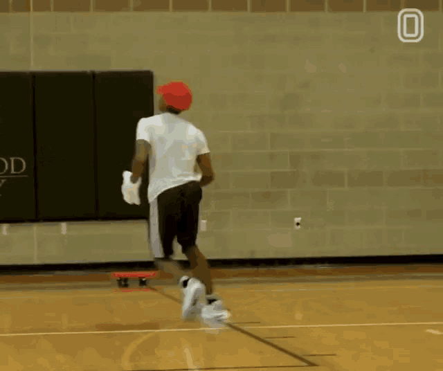 a man dribbles a basketball in front of a sign that says twood academy