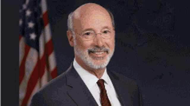 a man with a beard wearing glasses and a suit and tie
